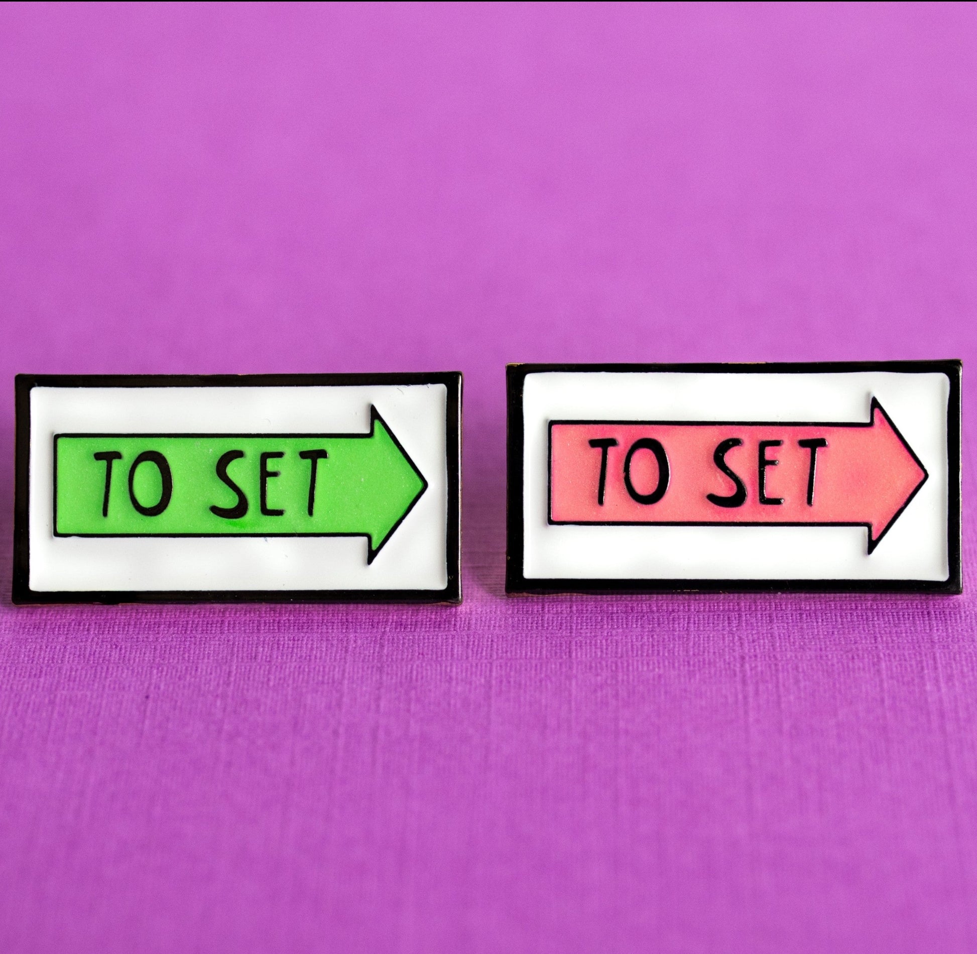 green and pink glow in the dark arrow film locations sign enamel pin